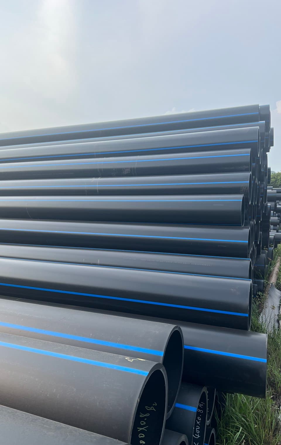 Gebündelte blau gestreifte und schwarze PE-Rohre im Freien, die Größen für Feldleitungen