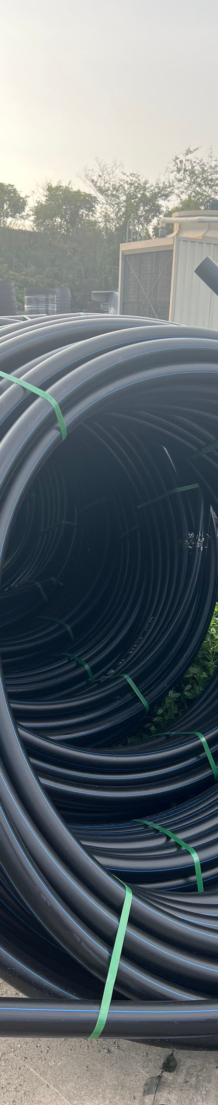 Structured wall drainage pipe stacked by diameter across the yard