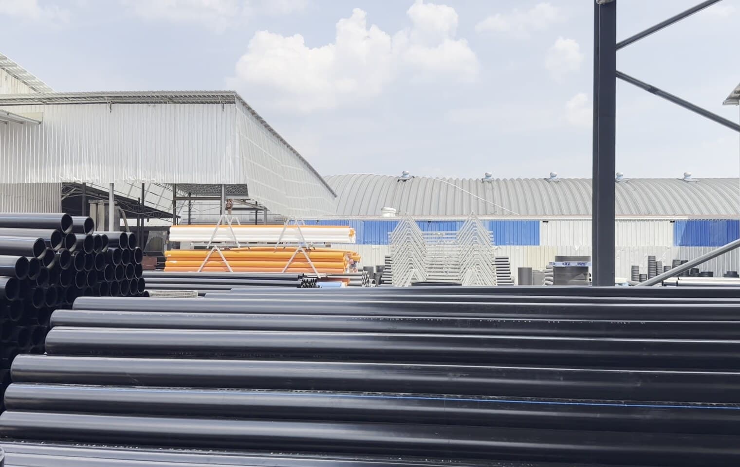 A wide view down our production hall, pipe stacked in the yard outside
