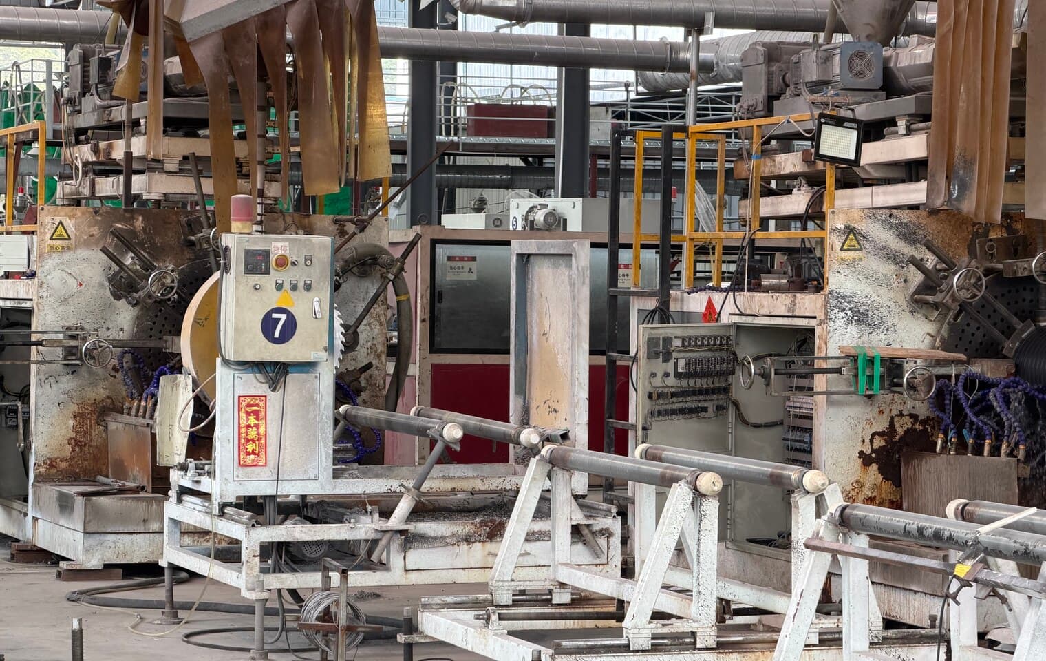 La tête d'extrusion d'une ligne de tube annelé, d'où sort une longueur de tube double paroi noir