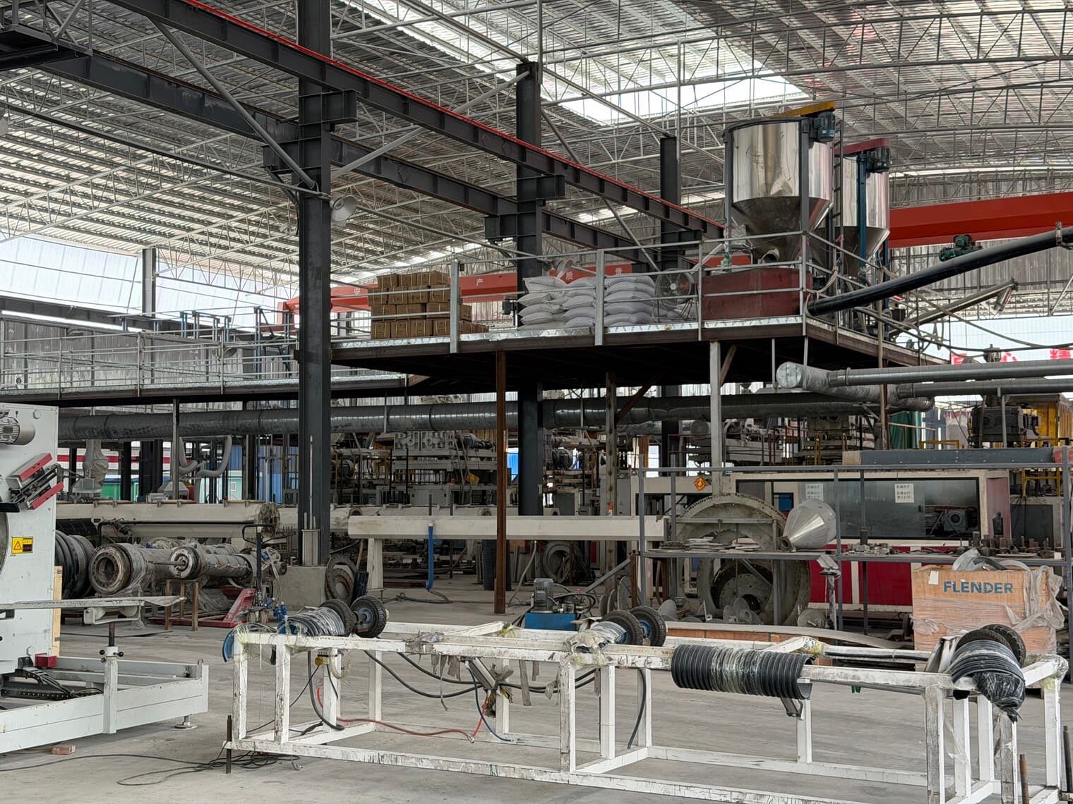 Dans l'usine : trémies d'alimentation au-dessus des fourreaux d'extrudeuse