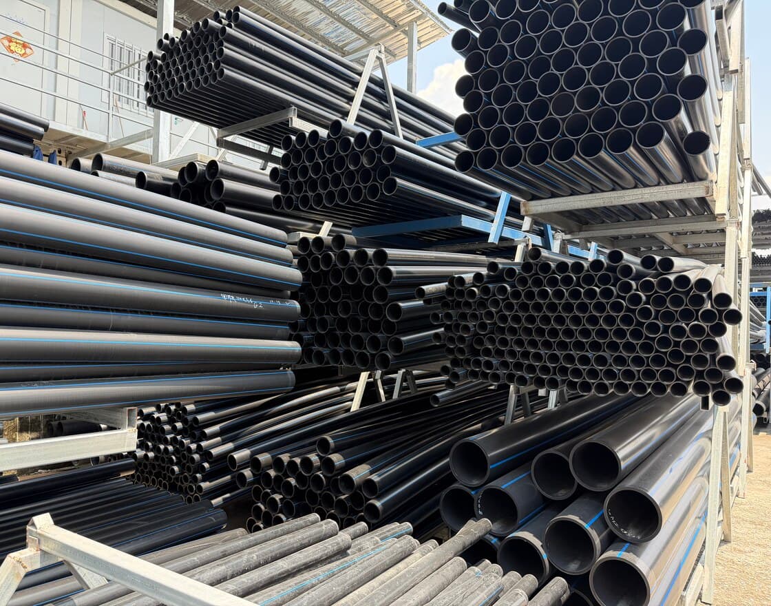أنابيب HDPE سوداء في ساحة التخزين لدينا، مرتّبة حسب القطر وأطرافها إلى الأمام