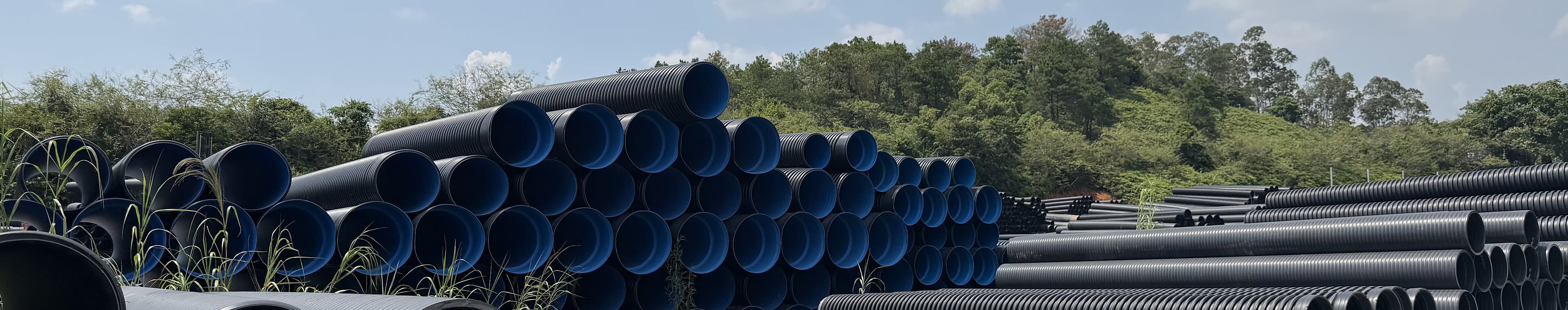 Structured wall pipe stacked by diameter across the yard, the drainage range in stock